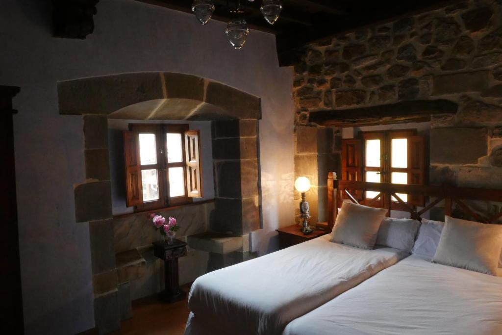 Abándames的住宿－Hotel Palacio La Cajiga，一间卧室设有两张床和两个窗户。