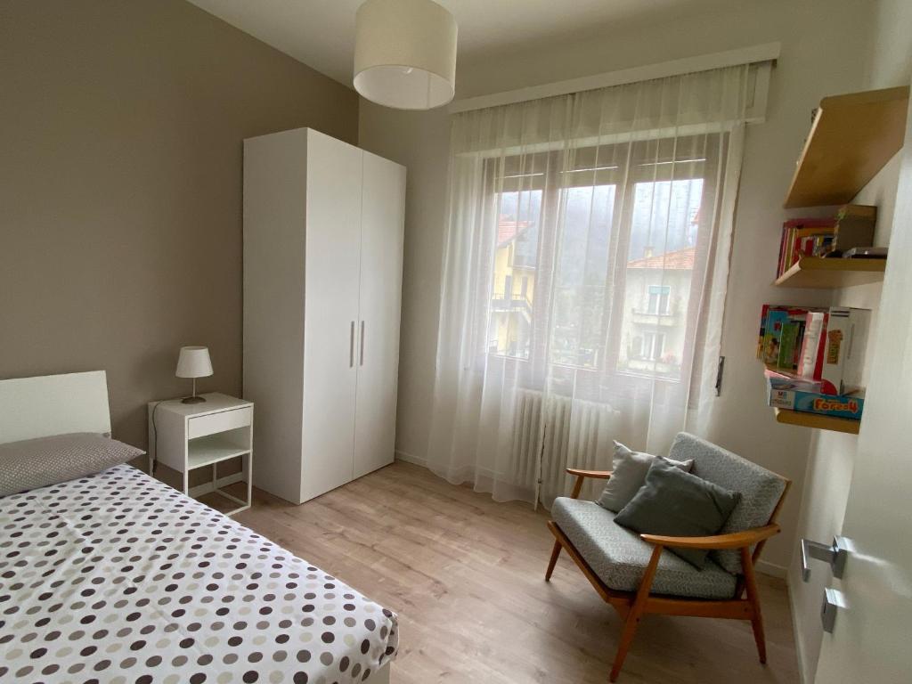 ein Schlafzimmer mit einem Bett, einem Stuhl und einem Fenster in der Unterkunft Verdelago in Cannobio