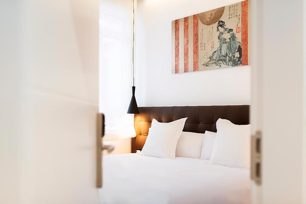 マドリードにあるWoohoo Rooms Boutique Lunaのベッドルーム1室(ベッド1台付)が備わります。壁には絵画が飾られています。
