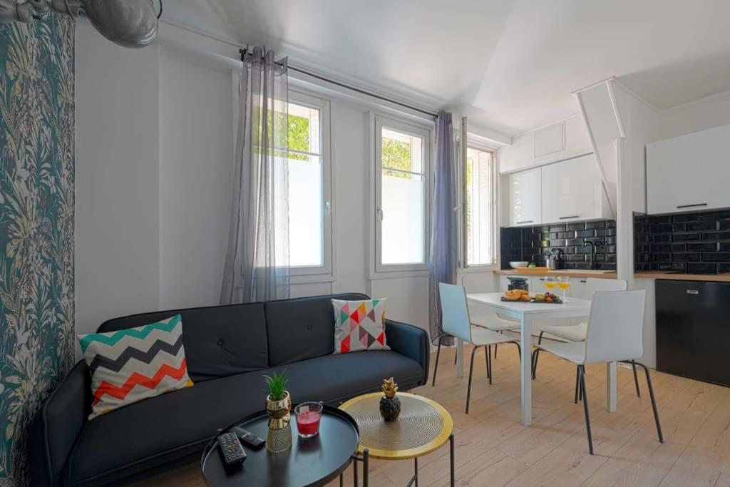 a living room with a couch and a table at Charmant 2 pièces à Issy- les -Moulineaux in Issy-les-Moulineaux