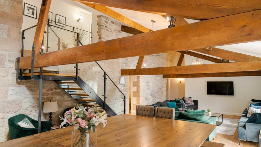 uma sala de estar com uma mesa de madeira e uma escada em Holly Bush Farm em Matlock