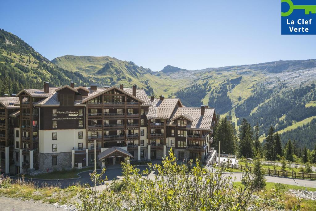 a hotel in the mountains with mountains in the background at Résidence Pierre & Vacances Premium Les Terrasses d'Hélios in Flaine