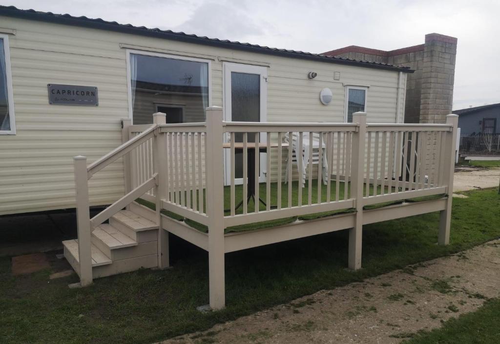 a mobile home with a porch and a deck at 6 Berth Caravan With Decking At Naze Marine Holiday Park Ref 17071p in Walton-on-the-Naze