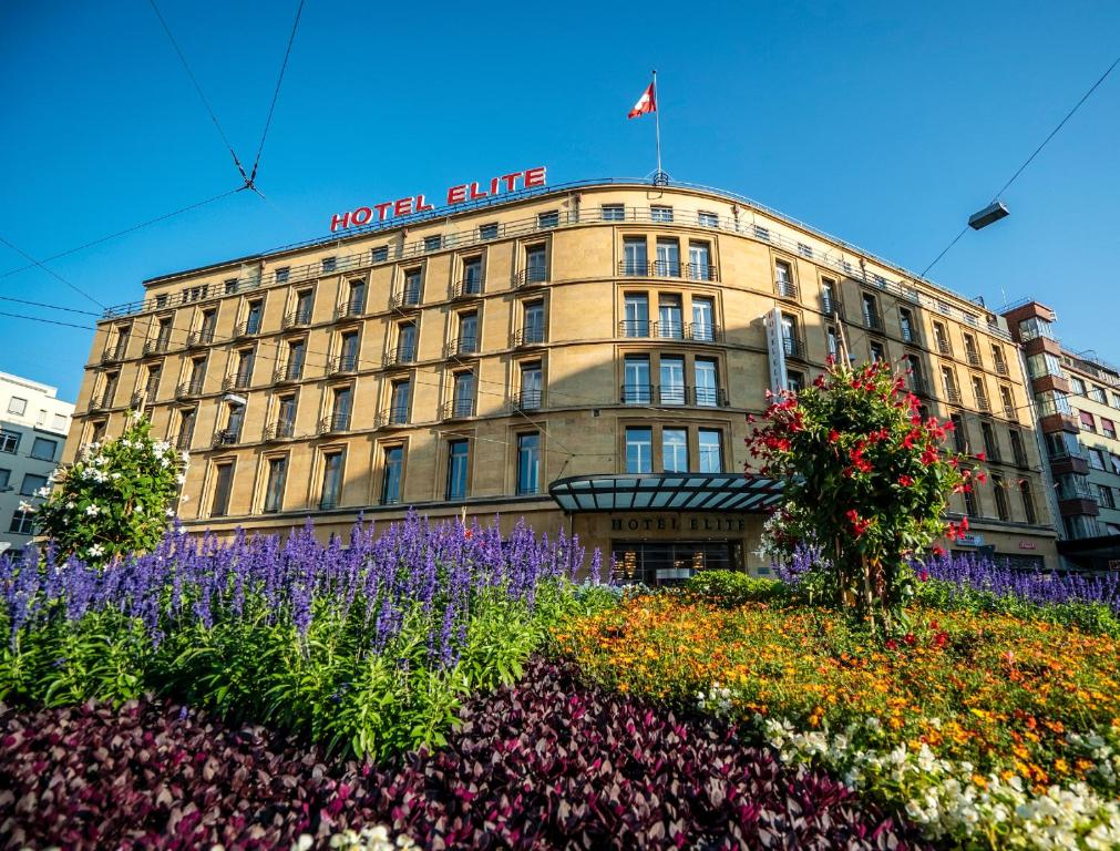 a hotel building with flowers in front of it at Art Déco Hotel Elite in Biel