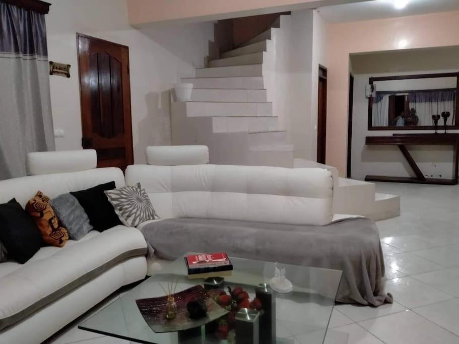 a living room with a white couch and a glass table at Kaza Mamai di Fora in Calheta