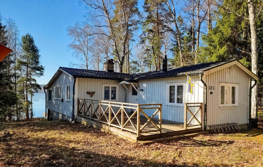 a small white house with a large porch at Lovely Home In Alingss With Lake View in Alingsås