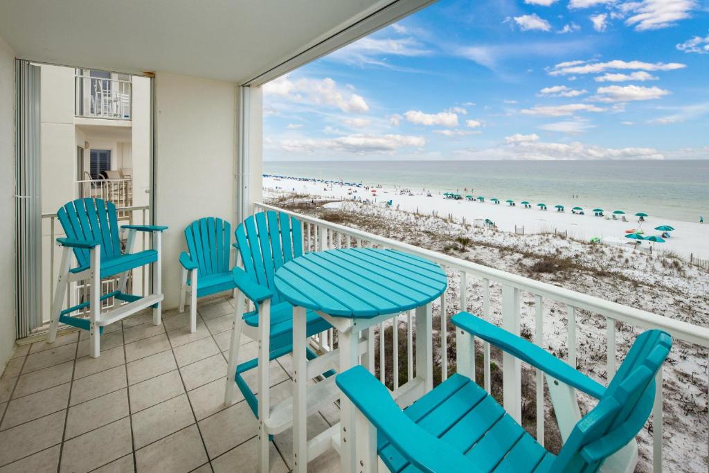 a balcony with blue chairs and a view of the beach at GD 411:THIS 3 BDRM IS TOP-OF-THE-LINE! THE UPGRADES ARE ASTONISHING in Fort Walton Beach