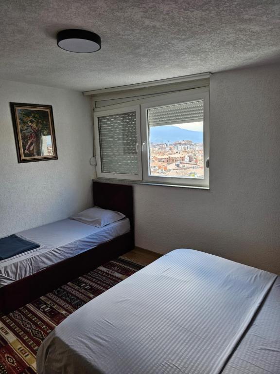 a small room with two beds and a window at Skyland Apartment Prizren in Prizren