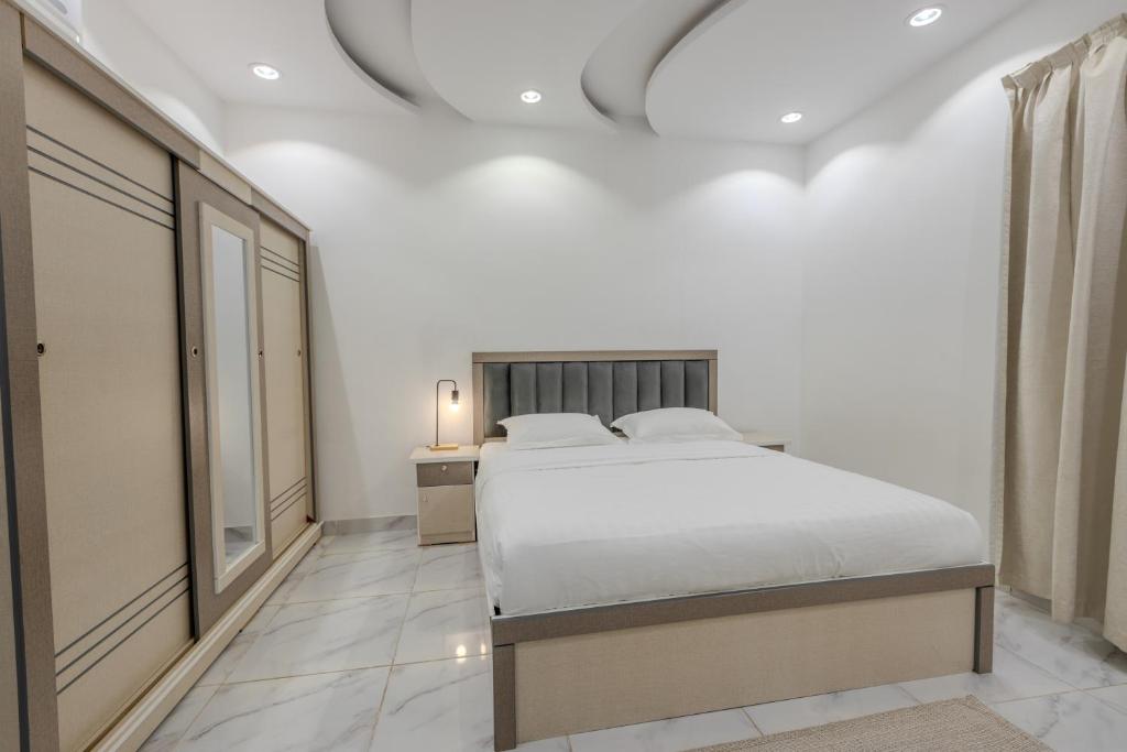 um quarto branco com uma cama e uma janela em Luxurious Family 3 Bedroom Apartments 10 Mins Drive to Al-Masjid Nabawi - Qaswarah residence em Al Madinah