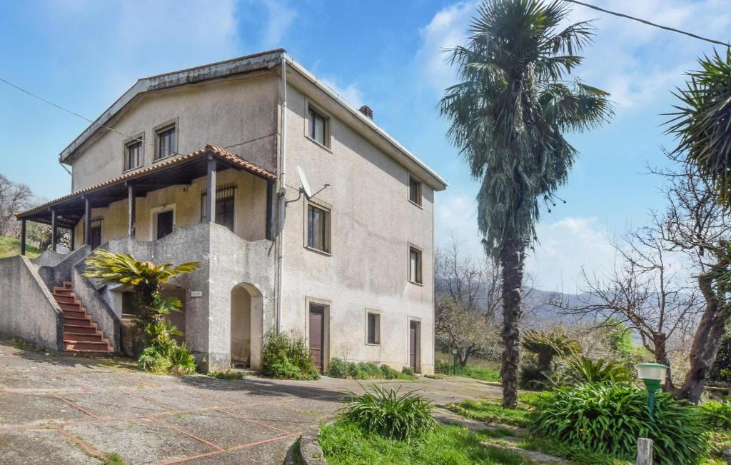 une vieille maison avec un palmier en face dans l'établissement 4 Bedroom Cozy Home In Cetraro - San Pietro, 