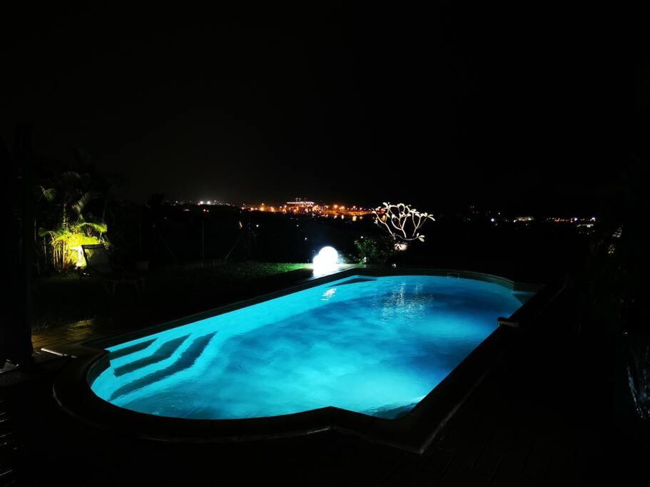 拉波瑟松的住宿－Villa Perroquet - vue mer - grande piscine chauffée，夜间游泳池,有灯光背景