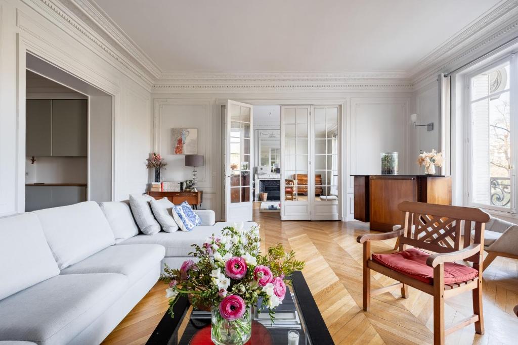 un salon avec un canapé blanc et une table dans l'établissement Veeve - Enlightened Elegance, à Paris