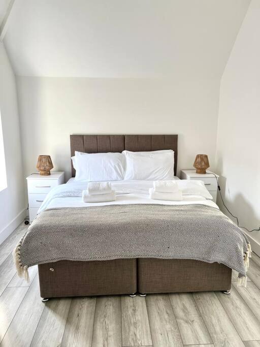 um quarto com uma cama grande e 2 mesas de cabeceira em Luton flat with parking em Luton