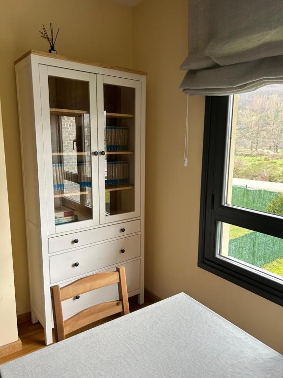 um quarto com um armário branco e uma janela em Lillo Home em Puebla de Lillo