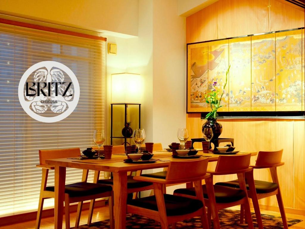 a dining room with a wooden table and chairs at 【BRITZ千種】貸切コンドミニアムホテル /千種駅徒歩３分 in Chikusachō