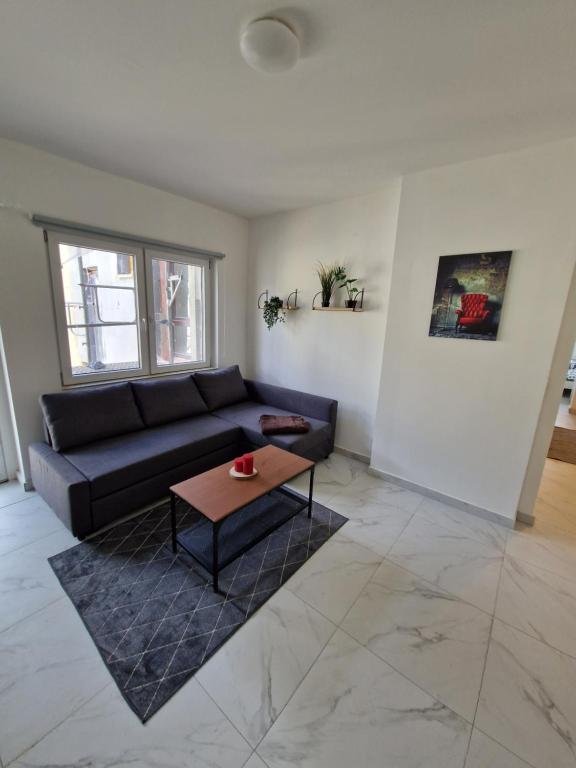 - un salon avec un canapé noir et une table dans l'établissement Apartment SweetDreams, à Bremerhaven