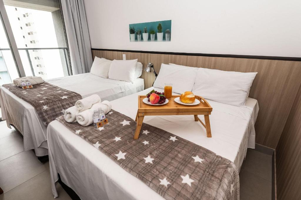 a hotel room with two beds and a tray of fruit on the bed at VS11 Studio Moderno Próximo ao Allianz Parque in Sao Paulo