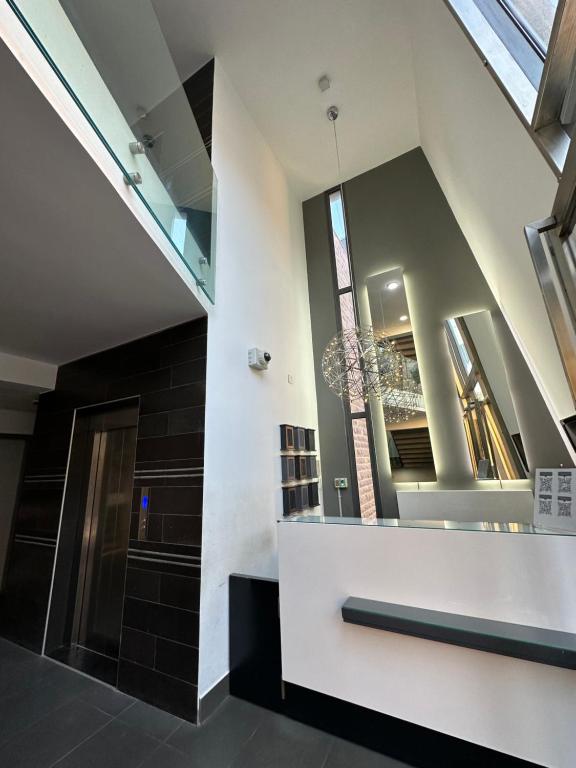 a lobby with a staircase and a mirror at Grey escape apartments in Qalḩāt