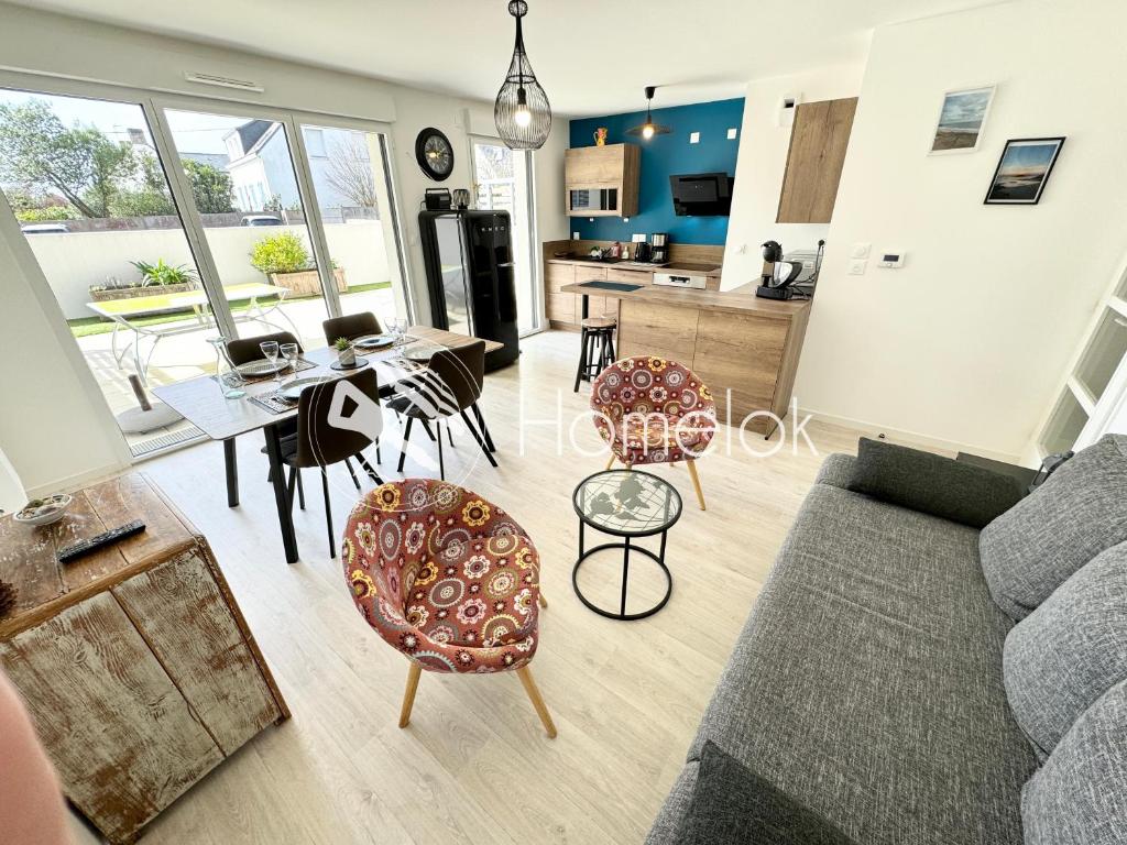 sala de estar con sofá, mesa y sillas en Bel appartement T3 de standing – proche de la mer, en Plouharnel