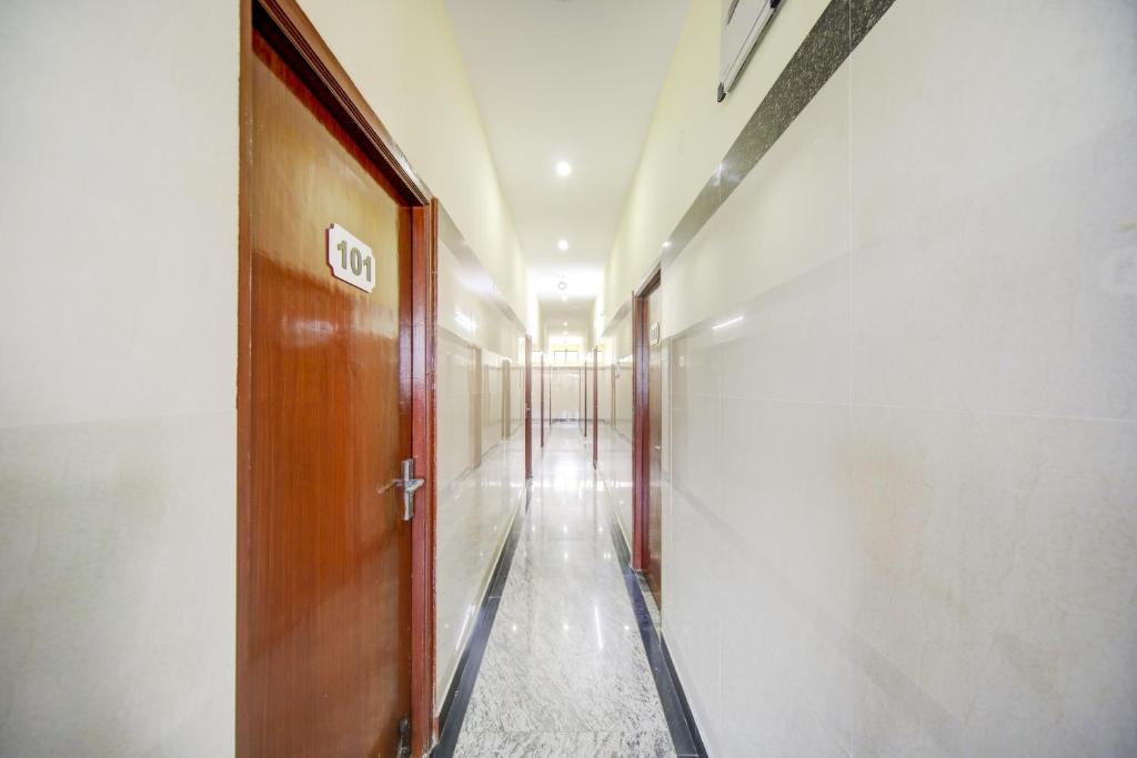 a hallway with a wooden door in a building at Super OYO Green Park in Vellore