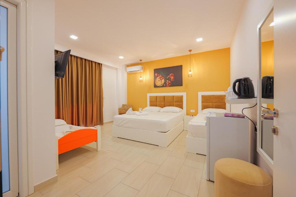 een hotelkamer met 2 bedden en een televisie bij Villa Family Garden in Ksamil