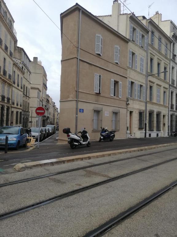 two motorcycles parked on a city street next to a building at Le mini Longchamp in Marseille