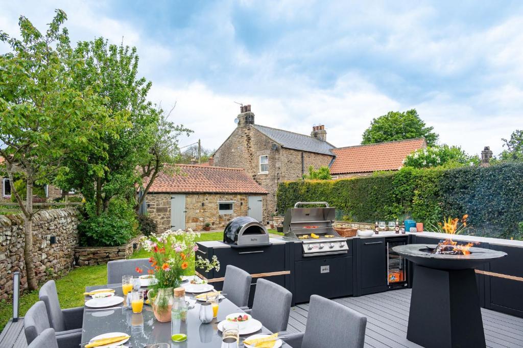 een patio met een grill, een tafel en stoelen bij Fairfield House in Newsham