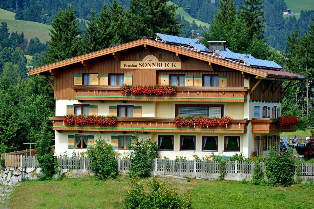 a large building with flowers in front of it at Pension Sonnblick in Westendorf