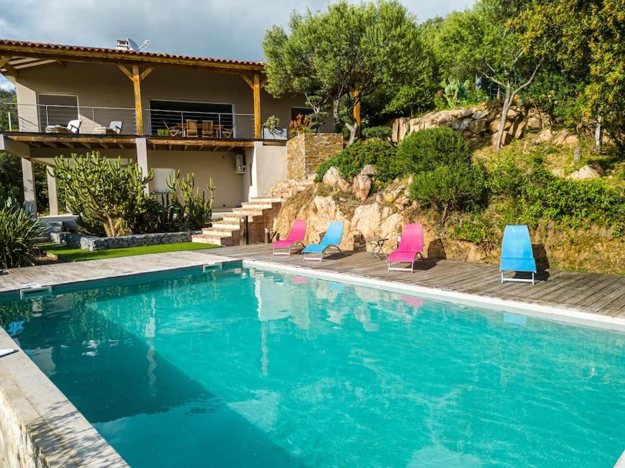 une piscine avec des chaises et une maison dans l'établissement Maison vue Mer et Maquis, à Olmeto
