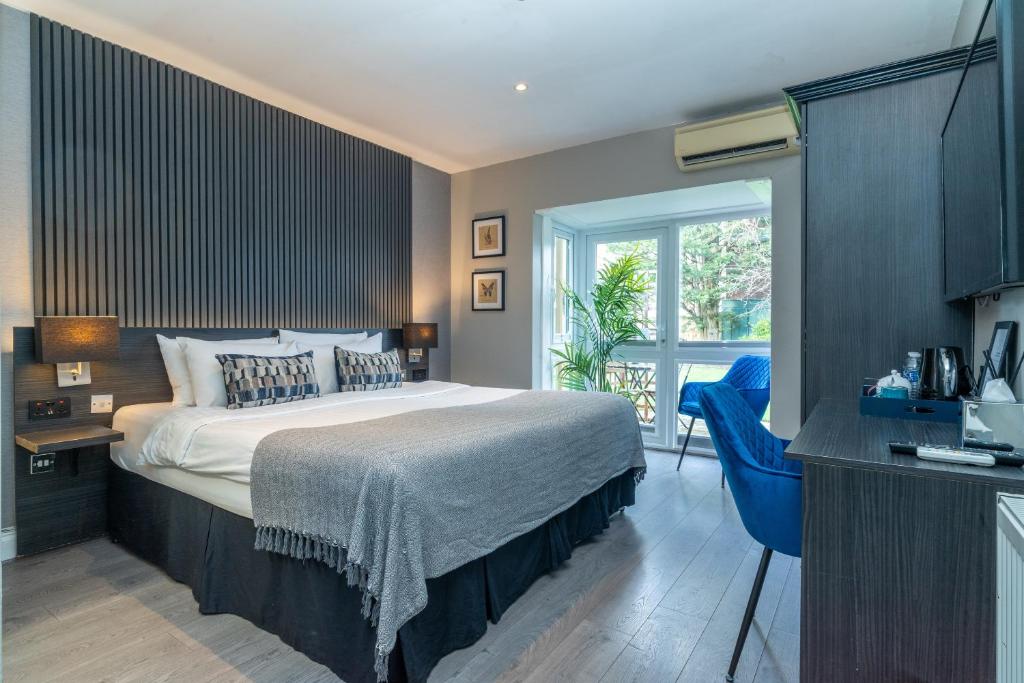 a bedroom with a bed and a large window at Croft Court Hotel in London