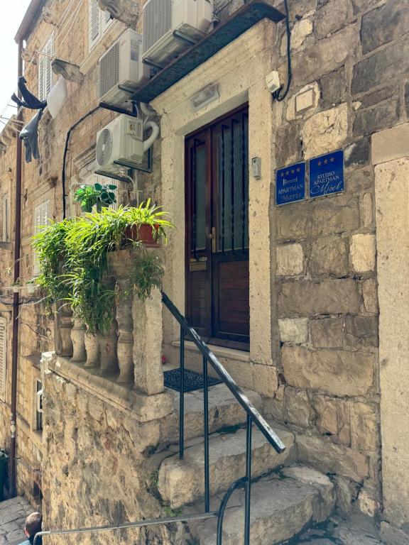 un edificio de piedra con una puerta y algunas plantas en Apartment Maris, en Dubrovnik