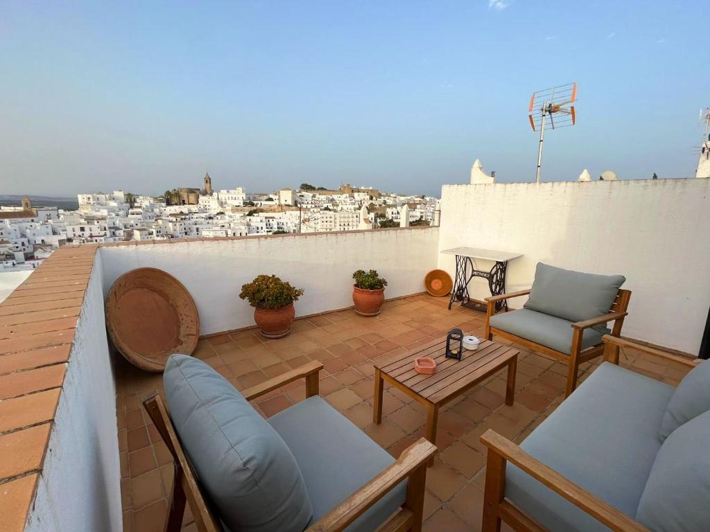 d'une terrasse sur le toit avec des chaises et des tables. dans l'établissement Casa Cebollino & Zarabanda, à Vejer de la Frontera