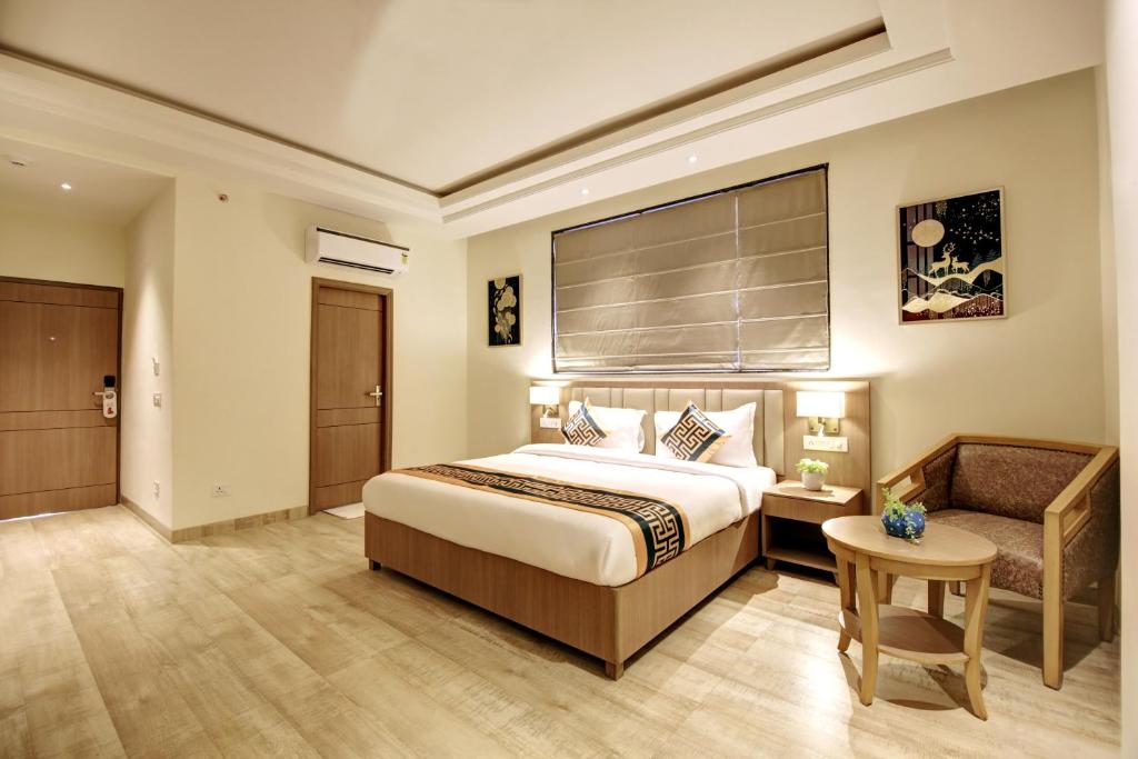 a hotel room with a bed and a chair at Hotel King Plaza in New Delhi