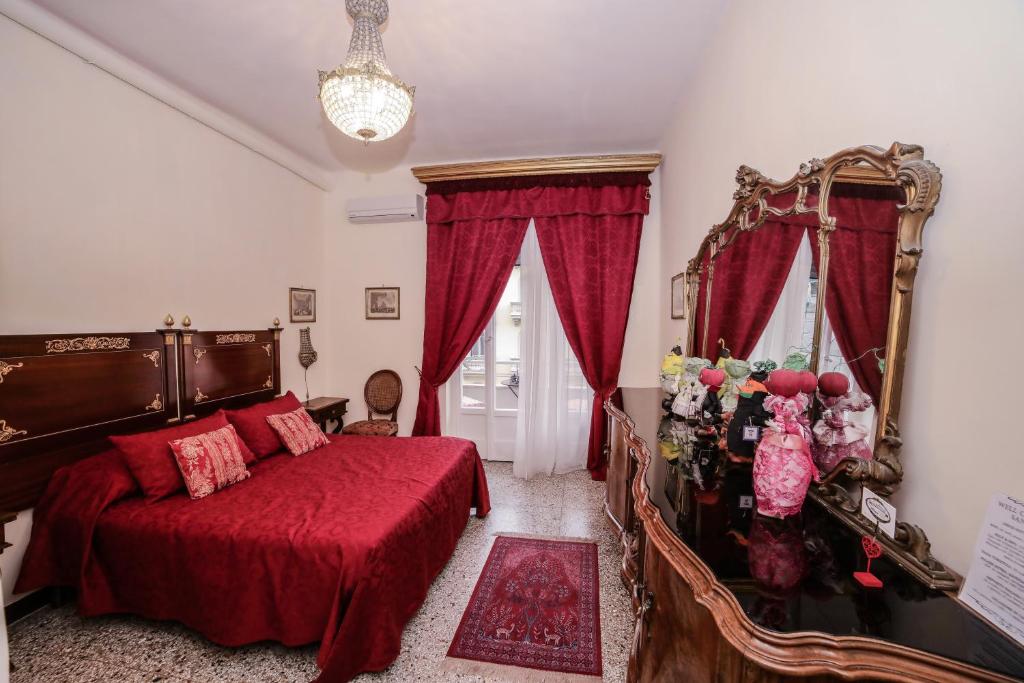 una camera con un letto con copriletto rosso di WELL COME - Lungomare SANTA LUCIA a Napoli