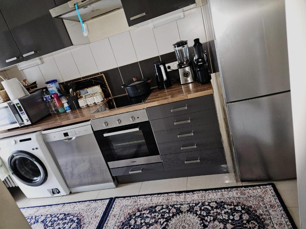een keuken met een wasmachine, een fornuis en een koelkast bij Luxurious 2 in Brussel