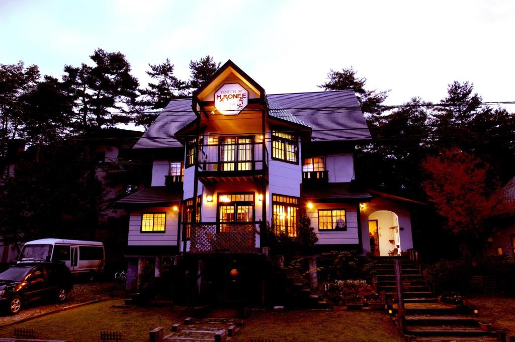 a large house with a clock on top of it at Pension Marionette in Hakuba