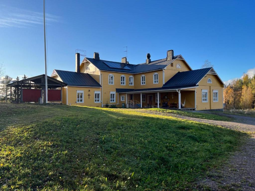 une grande maison jaune avec toit noir dans l'établissement Charming Studio-Perfect Getaway, à Nummistenkylä