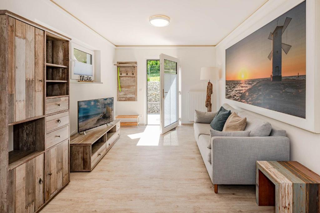 Una sala de estar con un sofá y un televisor. en Villa Doris Whg 6 Morgenrot, en Heringsdorf