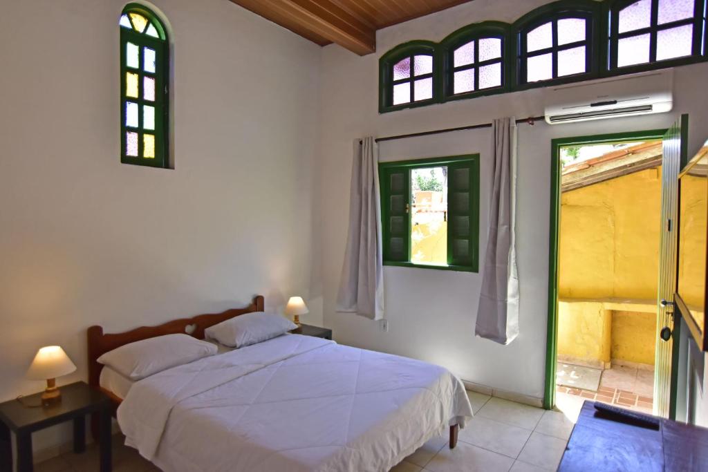 1 dormitorio con 1 cama y 2 ventanas en Villas Boas, en Arraial do Cabo