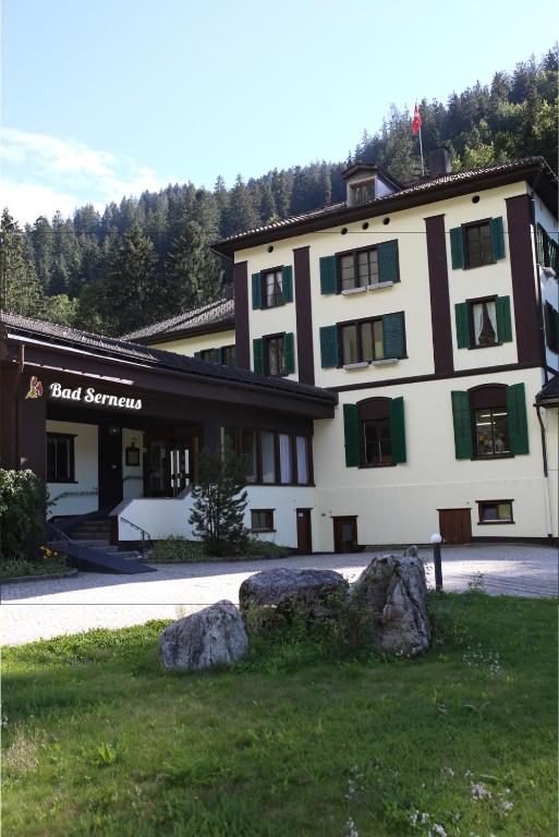 a large building with rocks in front of it at Hotel Bad Serneus in Klosters