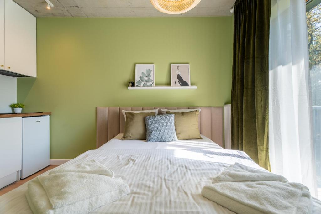 a bedroom with a large bed with green walls at Silver Forest in Szczecin