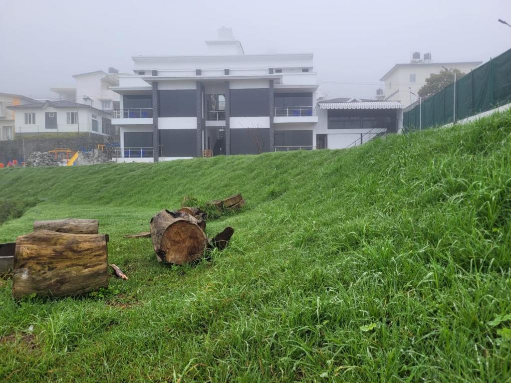 una pila de troncos sentados en una colina de hierba en Kodai Outdoor Valley, en Kodaikanal