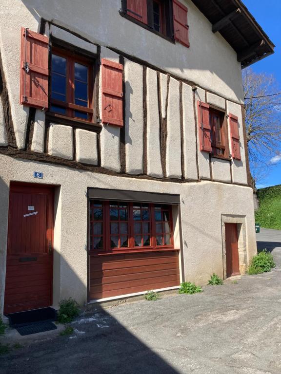 een gebouw met bruine deuren en ramen erop bij Chez Stella in Caylus