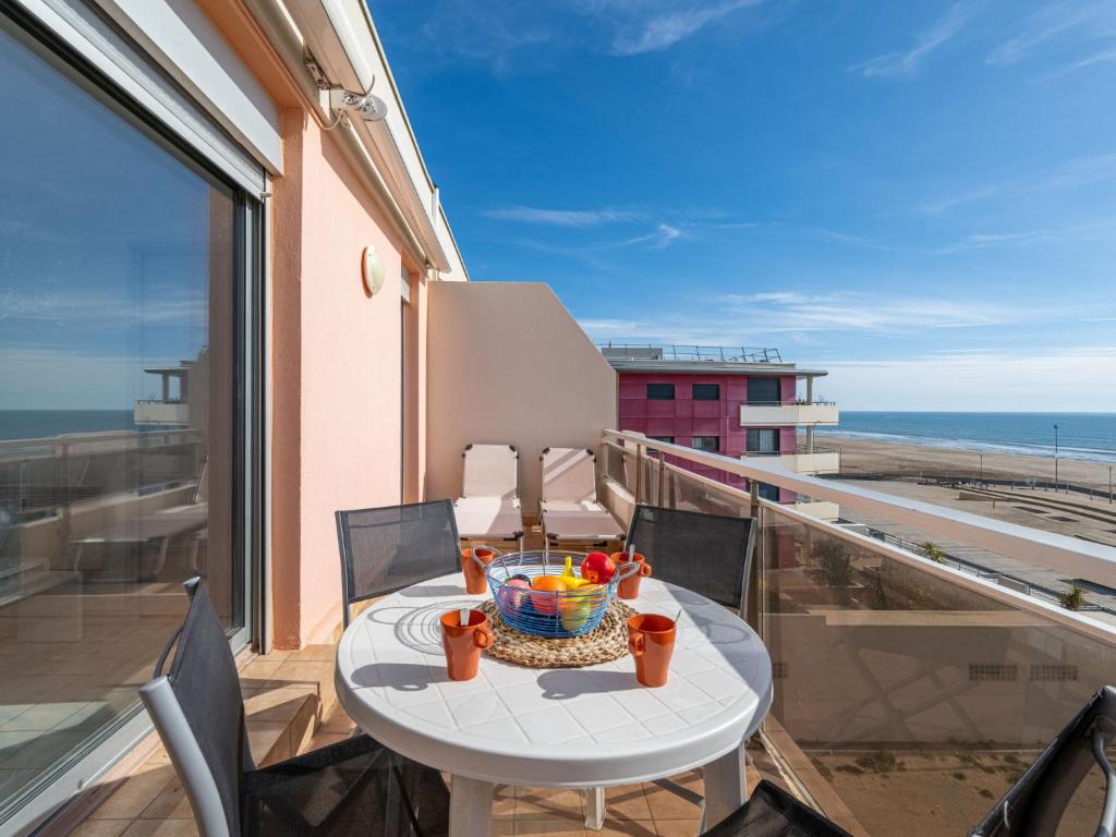 una mesa con un bol de fruta en el balcón en Apartment Les Terrasses du Levant by Interhome, en Narbonne-Plage