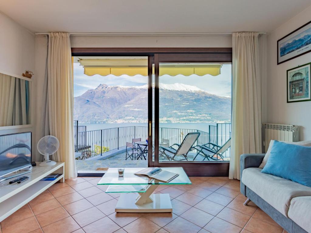 een woonkamer met een bank en uitzicht op de bergen bij Apartment Belvedere by Interhome in Bellano
