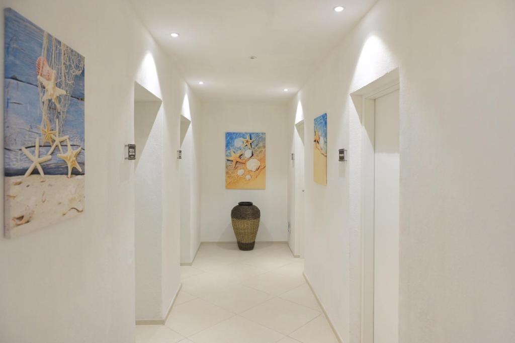 a hallway with white walls and paintings on the walls at Casa via Pascoli in Arzachena