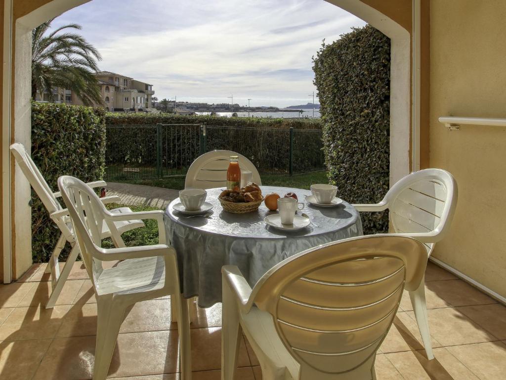a table and chairs on a patio with a table and a table and chairs at Apartment Les Rivages de Coudoulière-8 by Interhome in Six-Fours-les-Plages