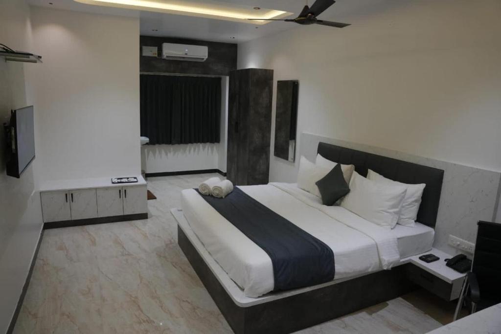 a bedroom with a large bed with a teddy bear on it at Goldeye's Inn in Erode