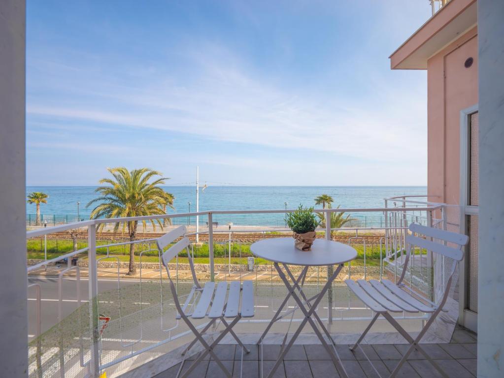 a balcony with a table and chairs and the ocean at Babyaccommodation Family Panoramic III in Pietra Ligure