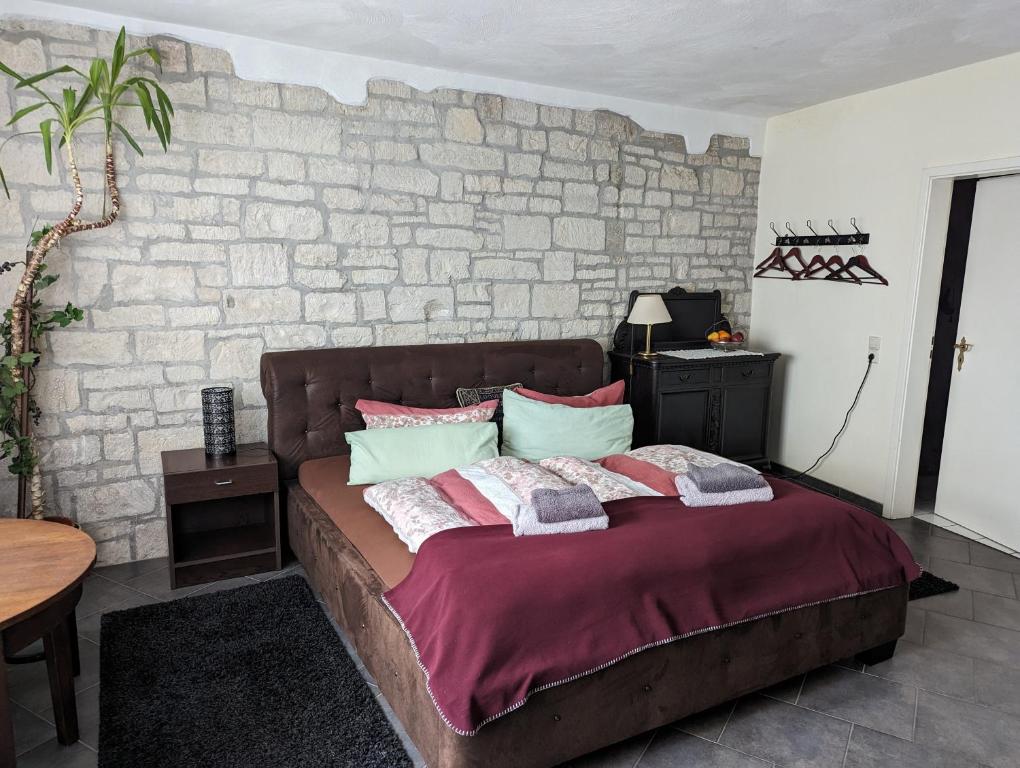 Ce lit se trouve dans une chambre dotée d'un mur en briques. dans l'établissement Gasthaus alt Freyburg, à Freyburg